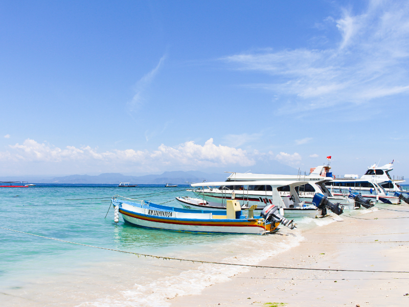 Boats on the shore of a beautiful white sand beach on Nusa Penida Island