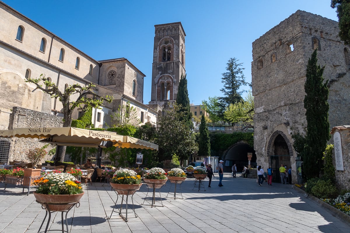 Quaint street in Ravello surrounded by potted plants and a snack bar