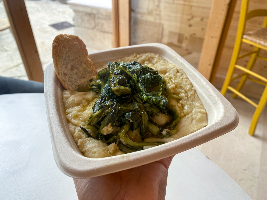 Holding a plate of fava bean stew - a must-eat during your Puglia road trip