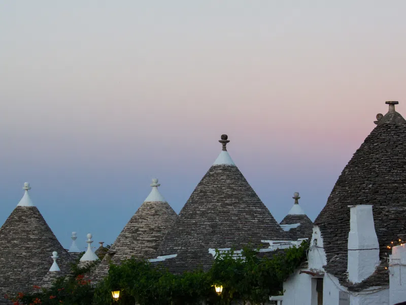 Trulli huts at sunset. One of the best things to do in Alberobello, Italy is to spend the night in your own trullo.