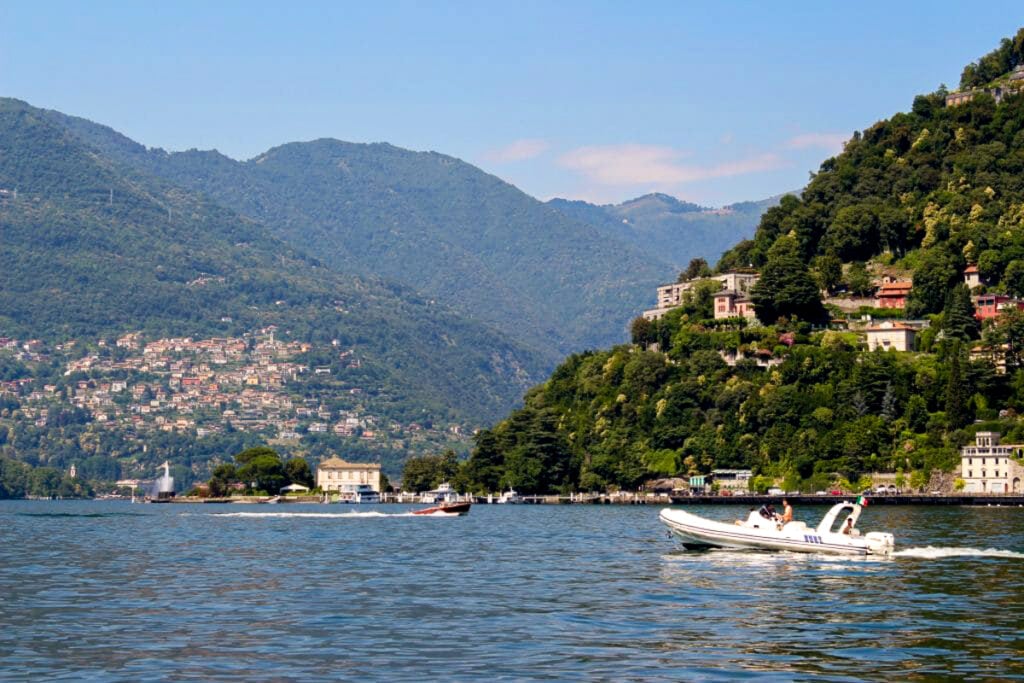 A boat cruising by on the water of Lake Como. A boat trip is a must-do activity during a day trip from Milan to Lake Como.