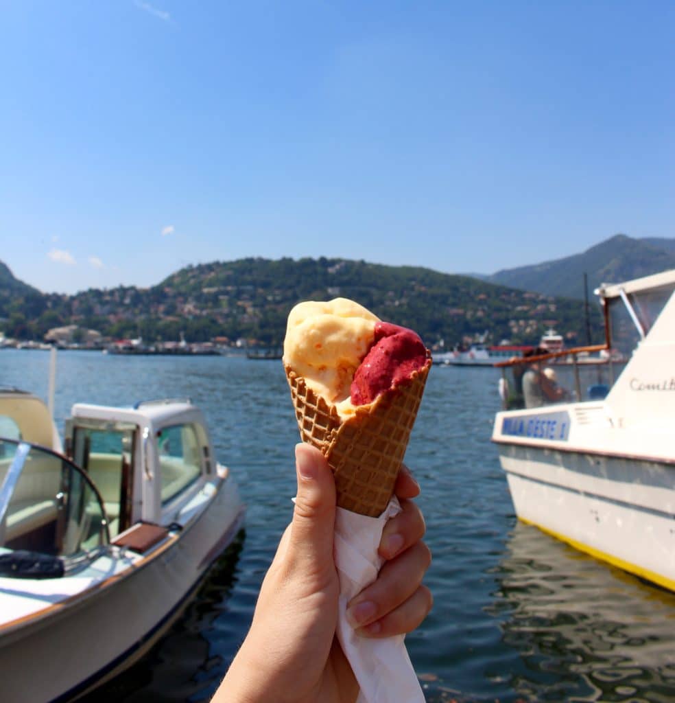Maddy eating gelato on the shores of the ancient city of Como. Como is one of the must-see towns on a day trip from Milan to Lake Como.
