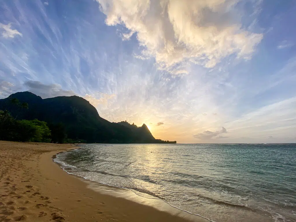 Beautiful sunset over the green mountains at Tunnels Beach in Kauai.