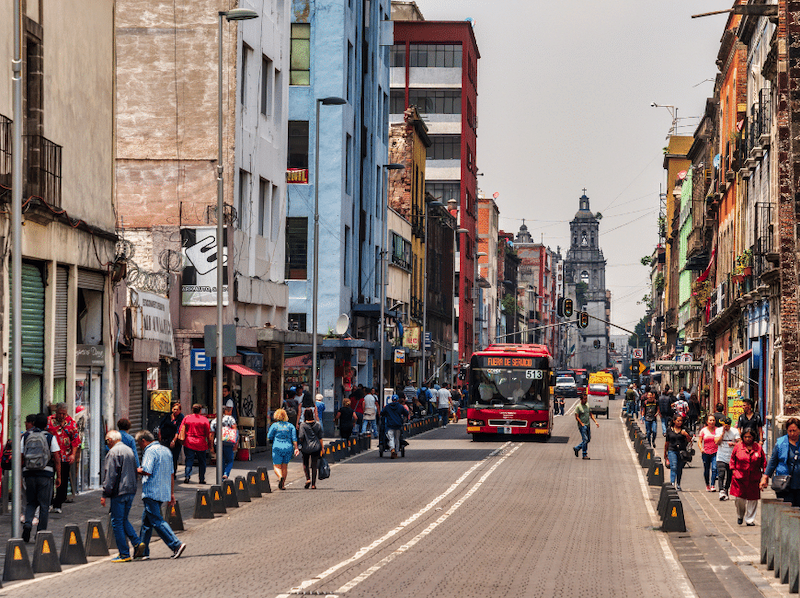 people walking on a main street in mexico city