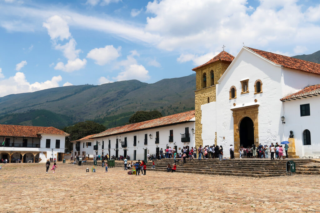 The main church in Villa de Leyva with a crowd on the front steps. Popping into the church is one of the best things to do in Villa de Leyva.