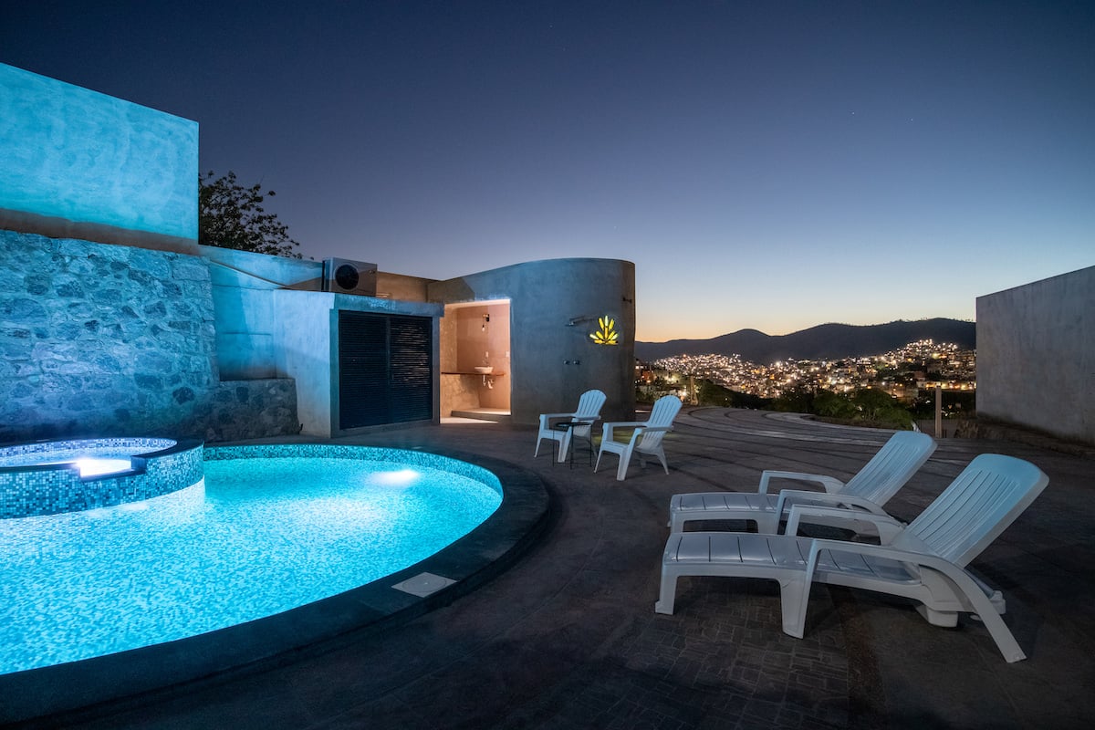 The pool at Casa de Tillie in Guanajuato City at dusk with views of the city in the background