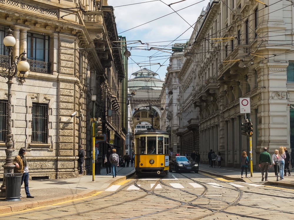 Yellow tram going through a street in Milan