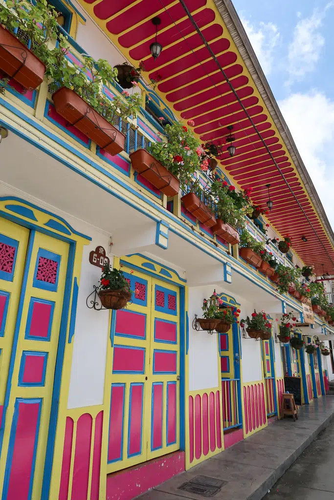 Colorful facades of houses decorated with hanging plants and potted flowers in a street in Salento