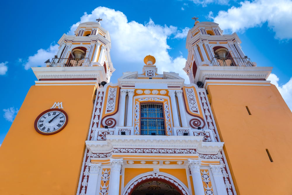 Yellow facade of the Lady of Remedies catholic church built on top of pyramid in Cholula.