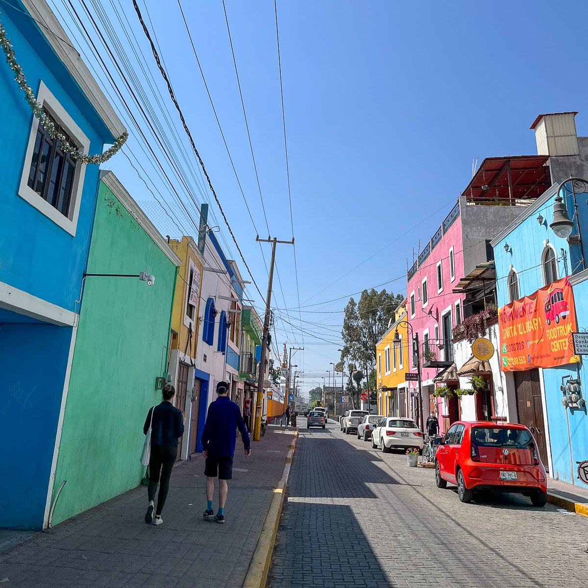 Maddy and Cacey walking down a very colorful street in Cholula