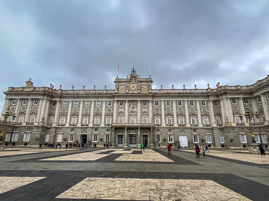 A view of the Royal Palace of Madrid under cloudy skies. This historical venue is a must-visit in your Madrid 1-day itinerary.