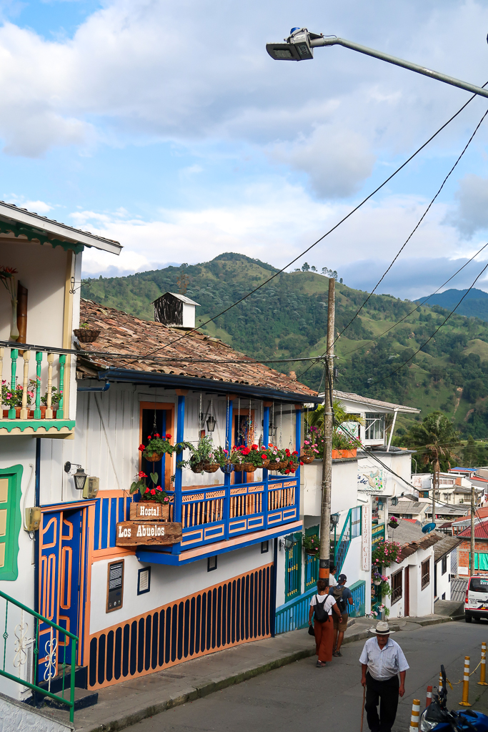 A colorful street in the center of the town of Salento with a few people walking around