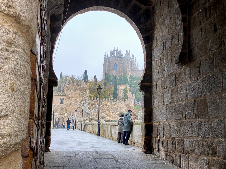 Tourists standing by a medieval bridge during a day trip to Toledo from Madrid