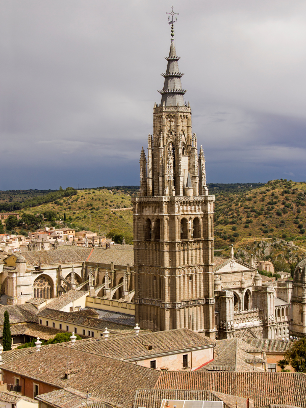 Bell tower of Toledo Cathedral standing tall among other old buildings surrounding it