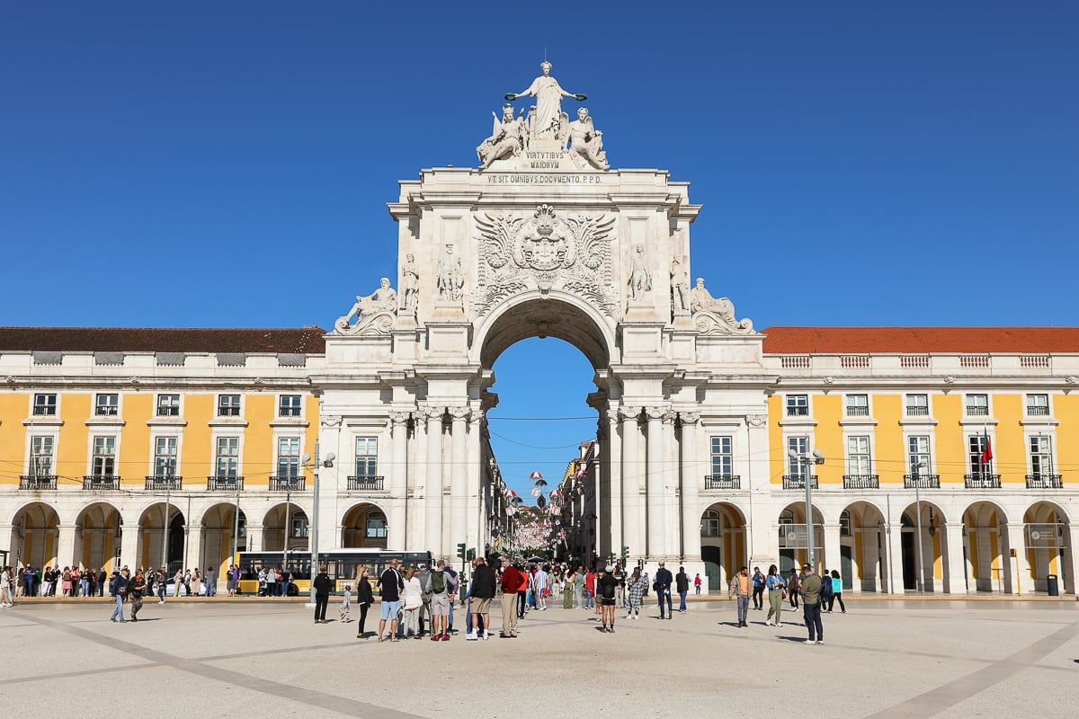 The famous Rua Augusta Arch with people roaming around on a sunny day