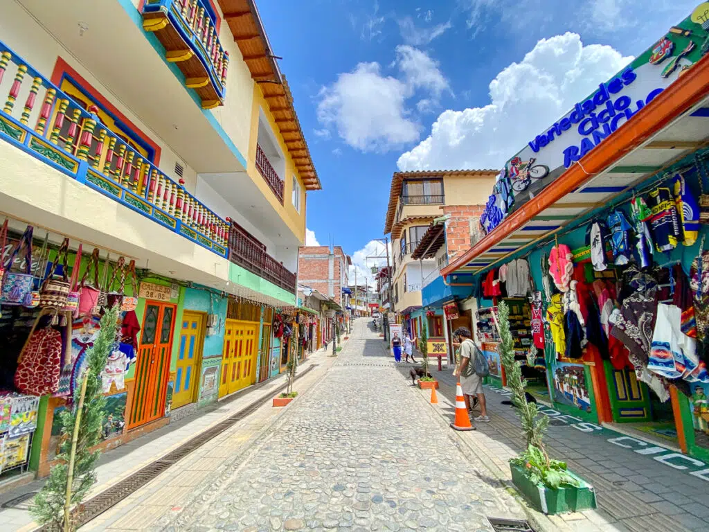 Cobblestone street lined with souvenir shops and colorful buildings on a sunny day