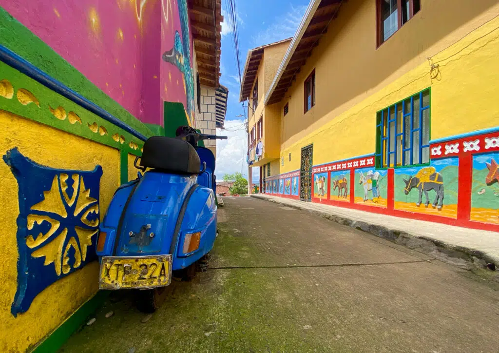 Blue scooter parked by a narrow, colorful street. In this Guatape travel guide, you'll find the best things to do and other things you should know.