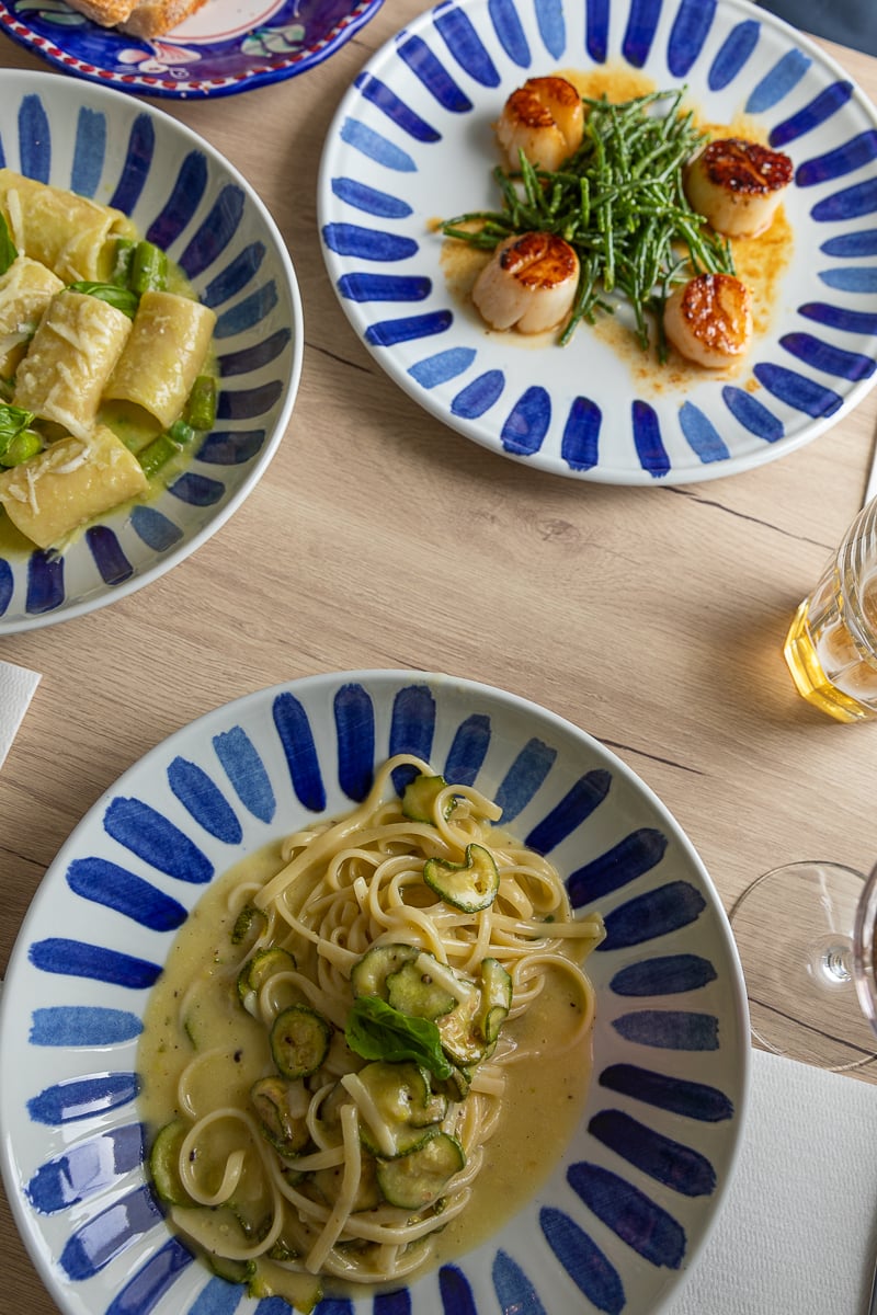 Decorative blue and white plates filled with Italian food