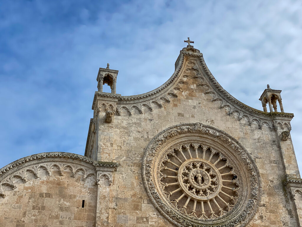 Rose window on the façade of Duomo di Ostuni. Visiting this cathedral is one of the things to do in Ostuni, Puglia.