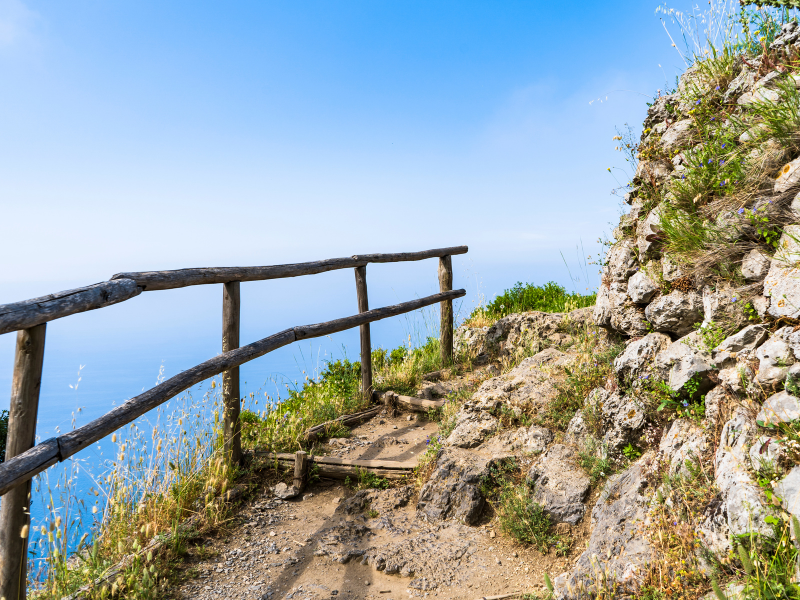 The Path of the Gods hiking trail, along a rocky mountainside with ocean views, is a must-do on your Amalfi Coast itinerary
