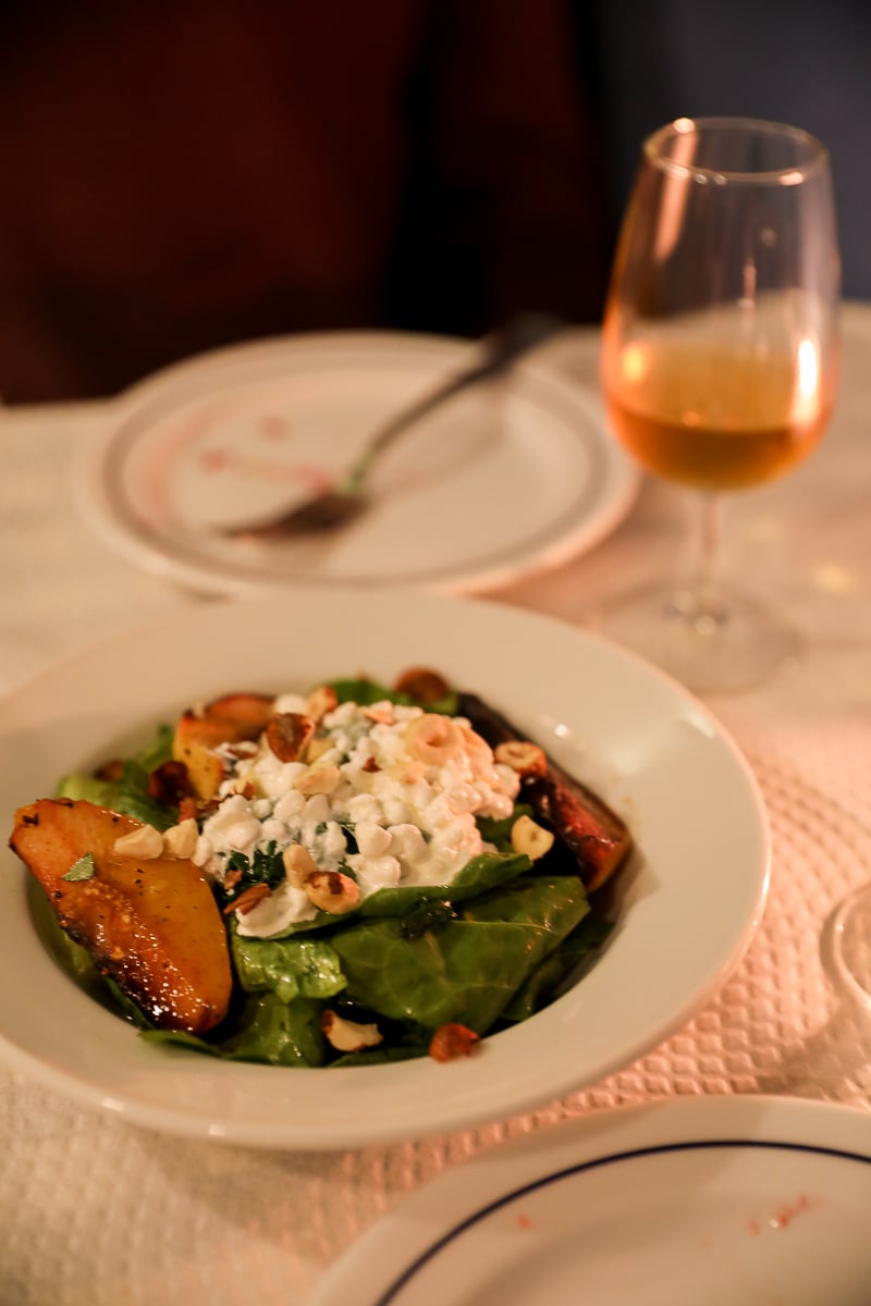 Plate of roasted quince dish and a glass of wine at Tasca Pete