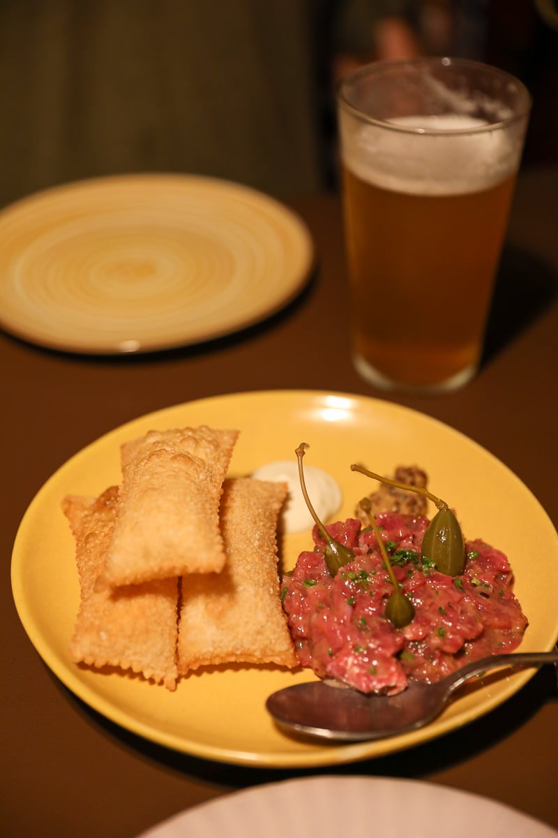 Plate of steak tartare + anchovy mayo, with pastel de feira at Tasca Baldracca