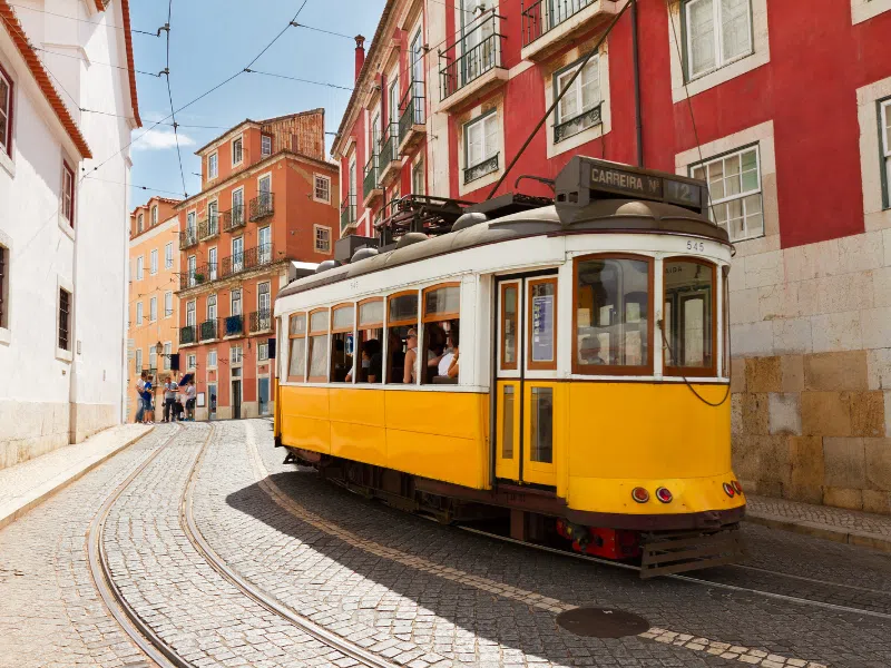 A tram traveling along a colorful street in Lisbon, Portugal