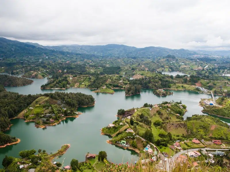 Beautiful view of the Laguna de Guatapé. Going on a sailboat tour to explore the lagoon is one of the best things to do in Guatape, Colombia.