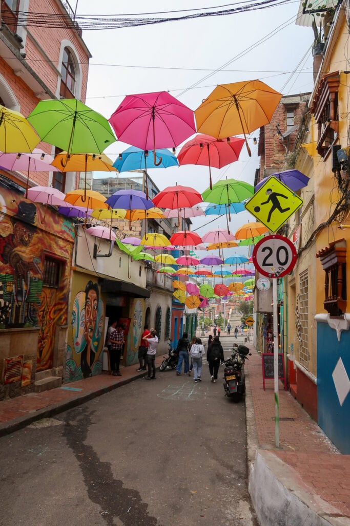 A street in Bogota decorated with colorful umbrellas and murals