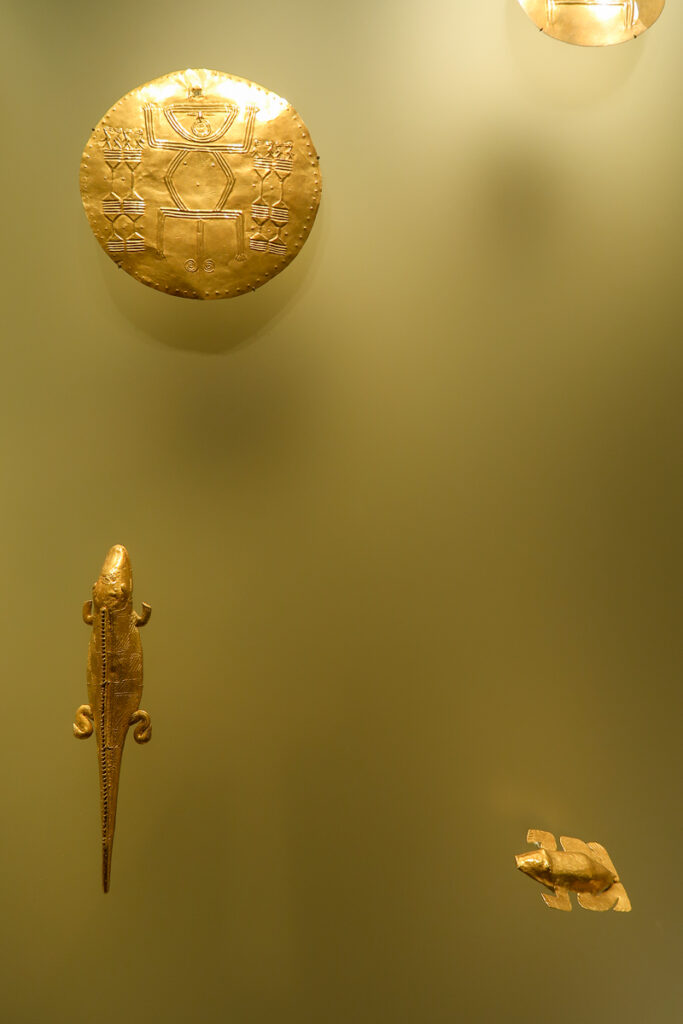 Golden figures of lizard and frog at the Gold Museum. These artifacts are some of the best things to see in Bogota, Colombia.