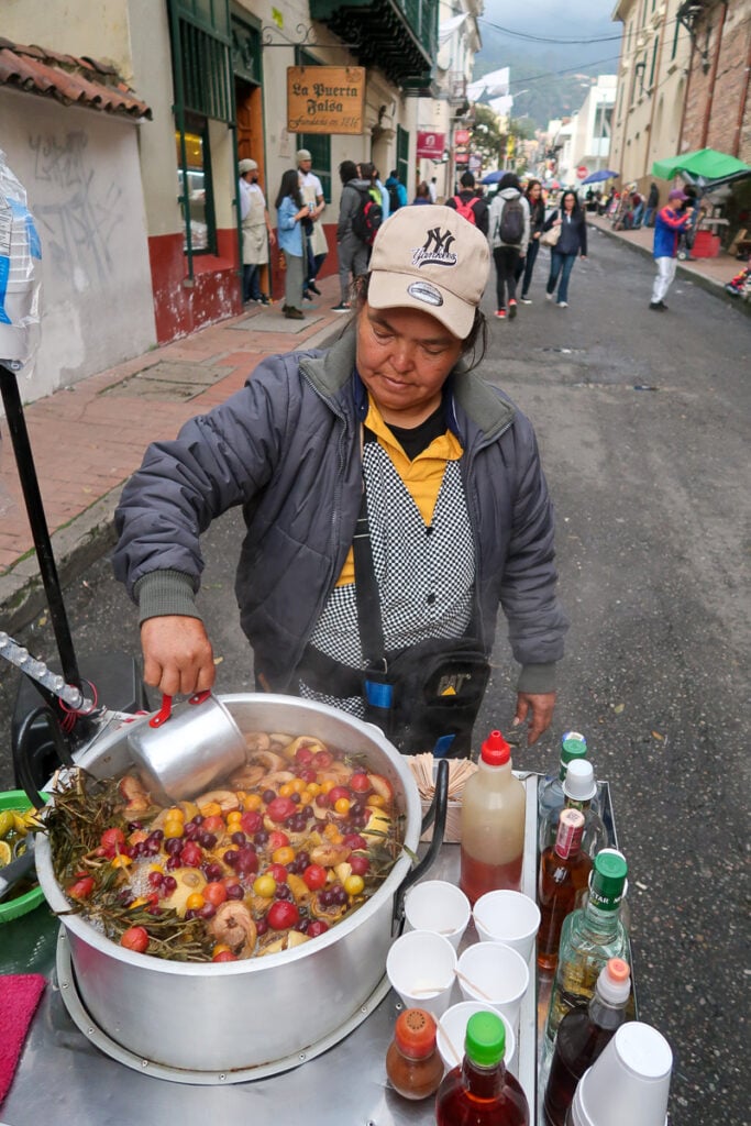 Street vendor scooping fruit juice from a pot