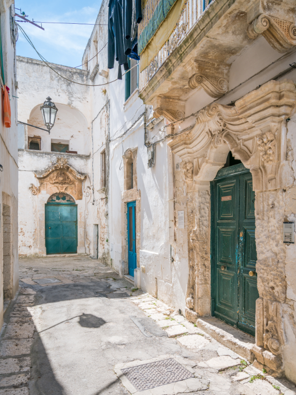 Lovely street in Ostuni and its colorful doors. Walking along these charming streets is one of the things to do in Ostuni.