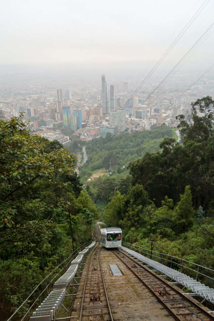 Cable car going down the Monserrate Mountain overlooking the whole town of Bogota on a cloudy day. Riding a cable car is one of the top things to do in Bogota.