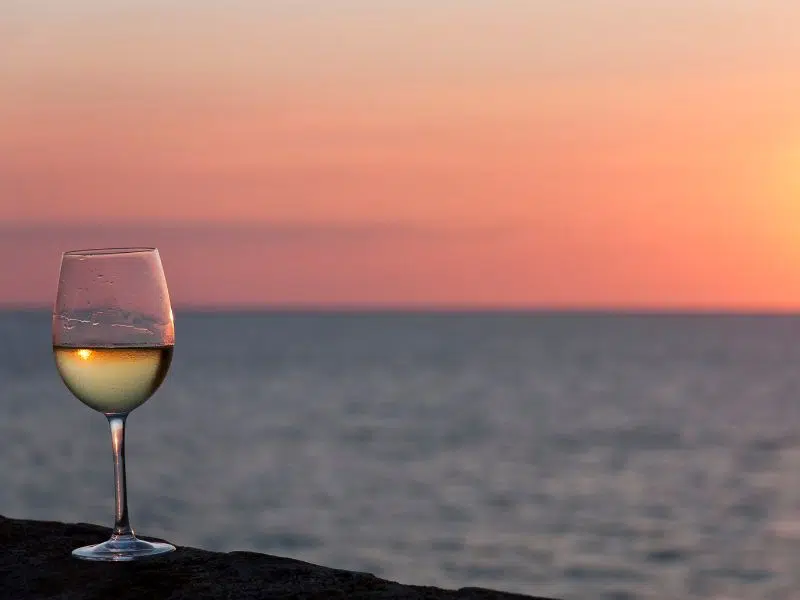 Glass of wine by the seaside at sunset