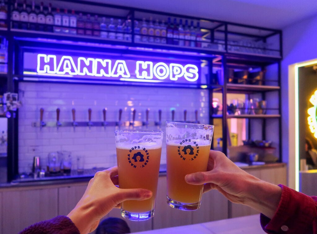 Holding up two glasses of beer at Hanna Hops in Bogota