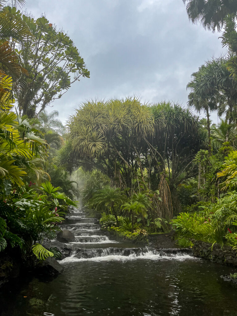 Cascading waterfalls surrounded by lush trees. Relaxing on a natural hot springs resort is one of the incredible things to do in La Fortuna.