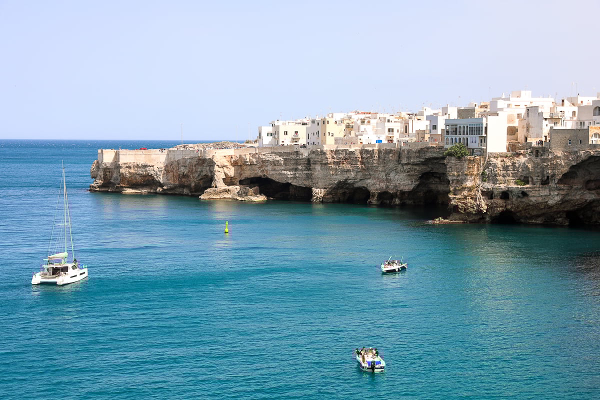 White boats cruising around Polignano a Mare. One of the things to know before going to Puglia is you'll never run out of beautiful views to see around.