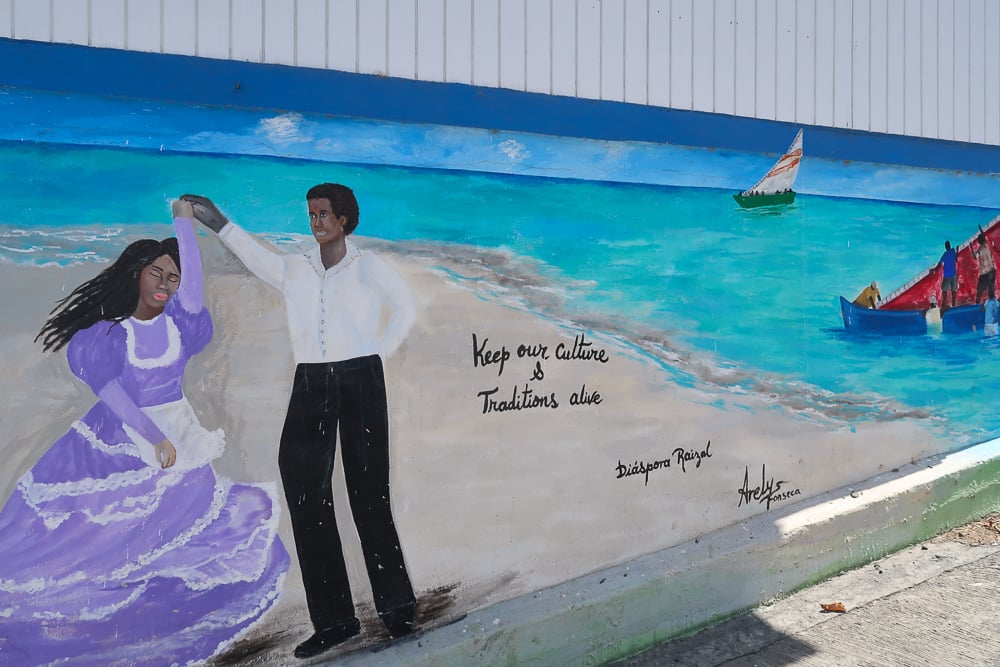 Colorful mural of a couple dancing on a beach, with words "Keep our culture and traditions alive"