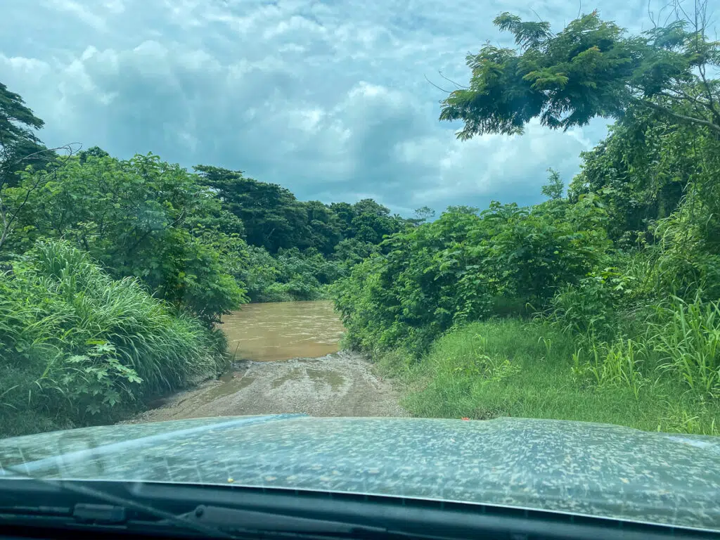 View of a road flooded by a river on the way to Nosara, Costa Rica