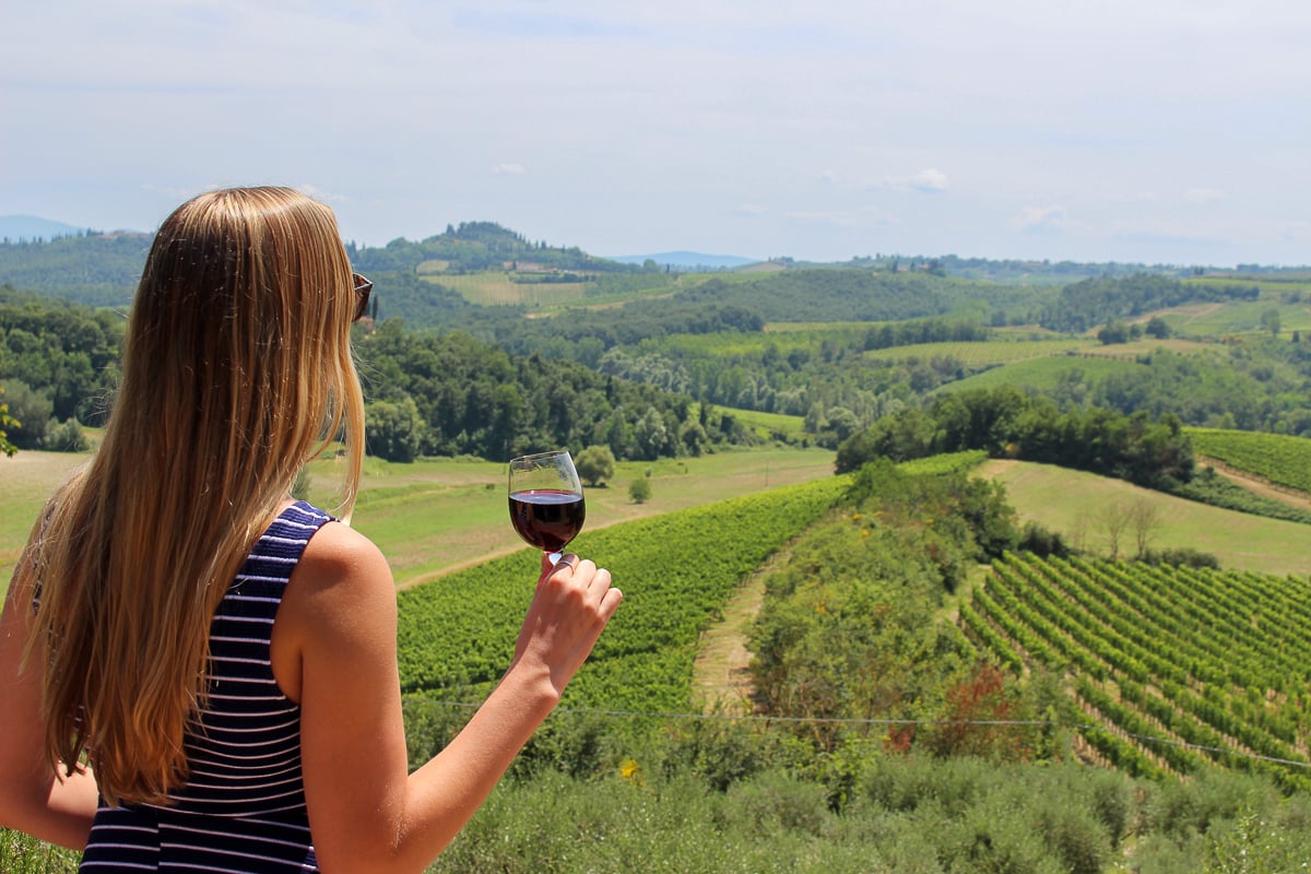 Maddy drinking red wine and overlooking vineyards in Tuscany