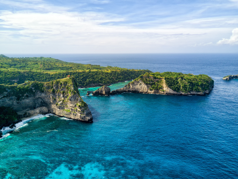 A beautiful aerial view of Nusa Penida's azure waters and green coky cliffs