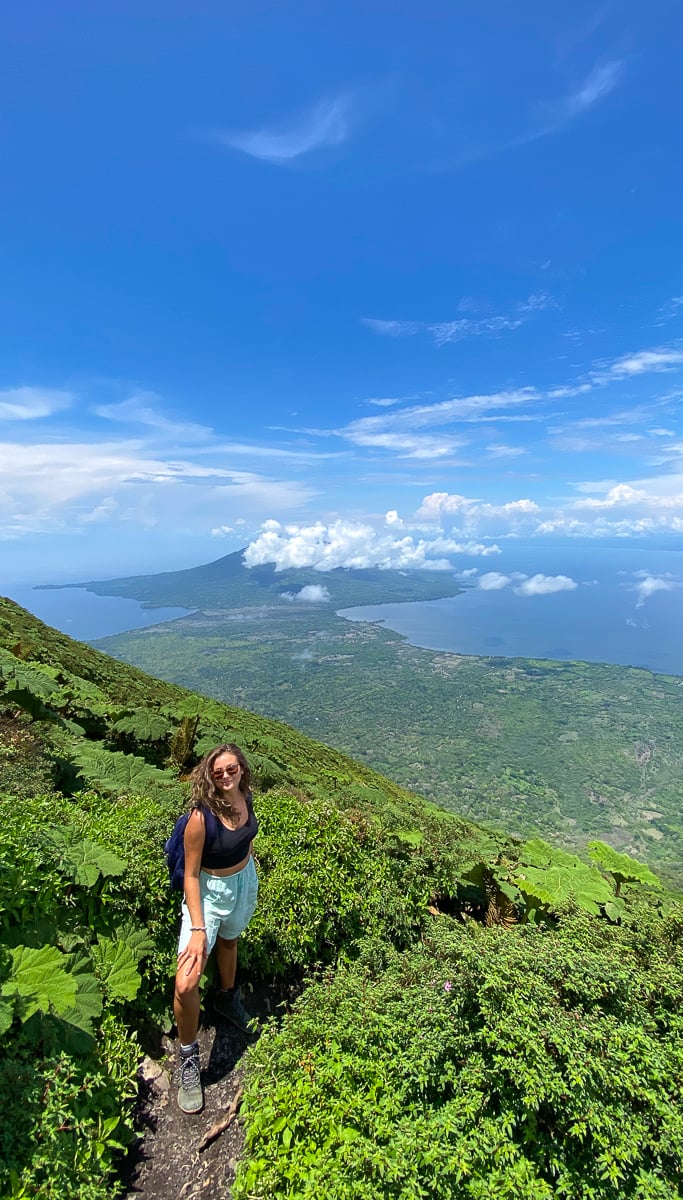 Melanie, blogger, standing on an uphill hiking trail.