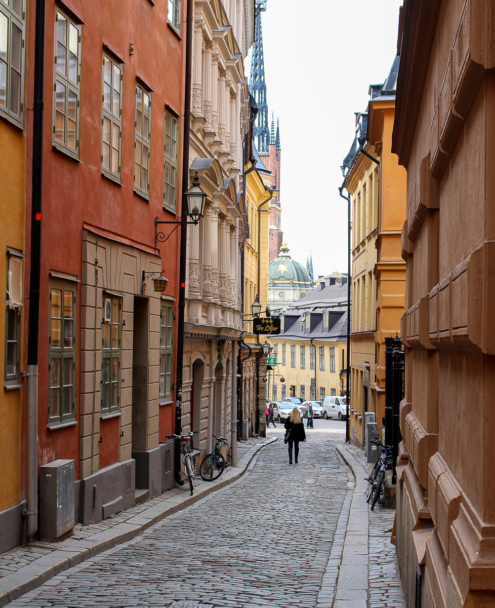 A woman walking down a pretty street in Stockholm Old Town