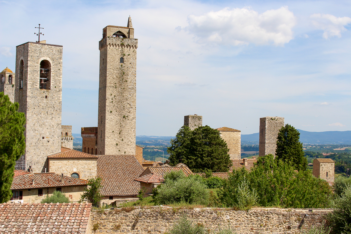 Towers of San Gimignano with green Tuscan hills in the background