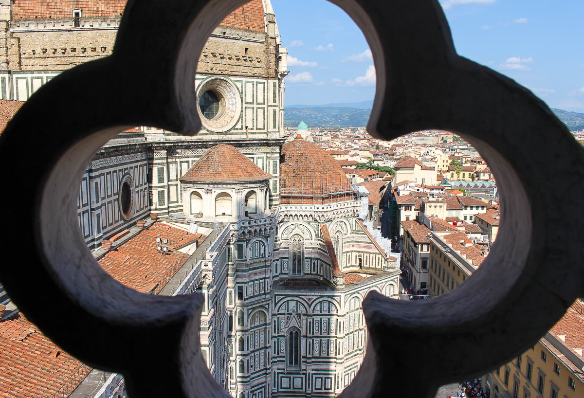 Looking through a clover-shaped window to see the dome of Duomo