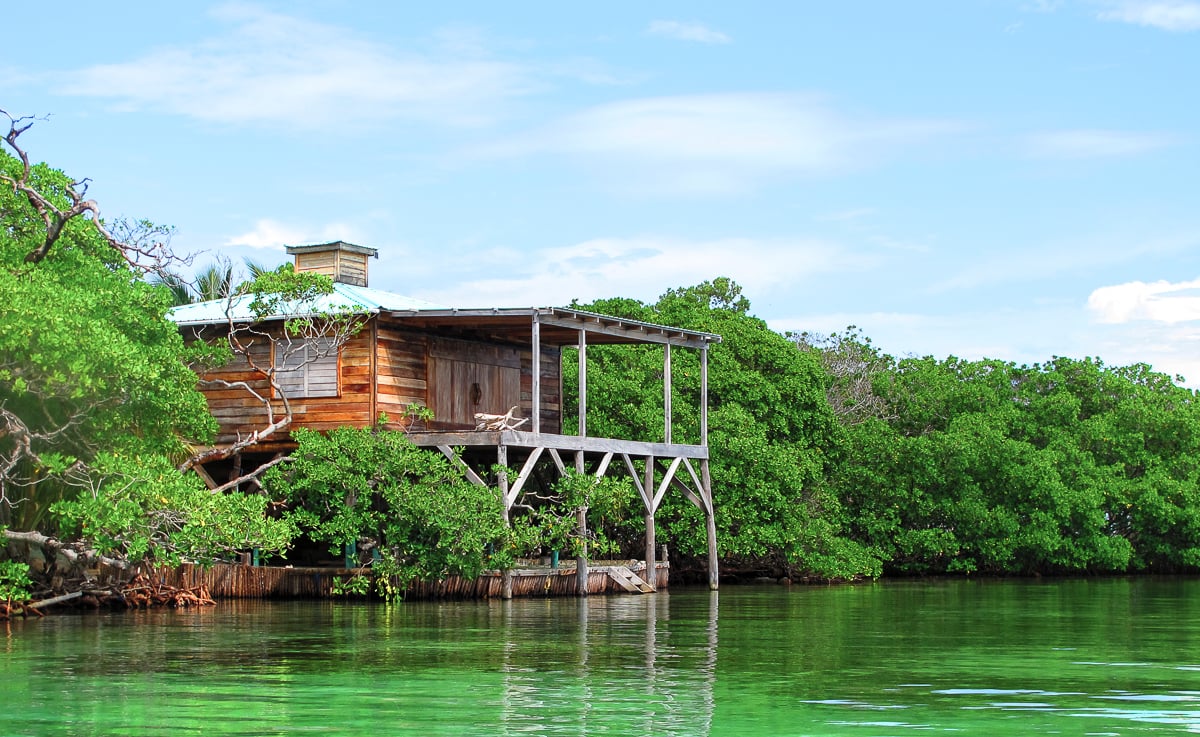 A stilted wooden home over the water on a caye in Belize. 