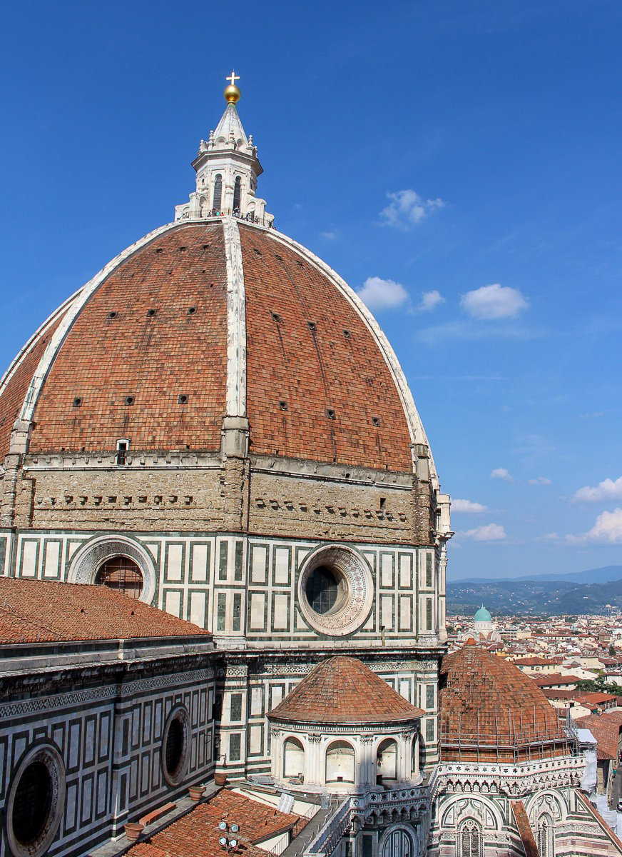 Brick dome of the historical Duomo under the blue sky