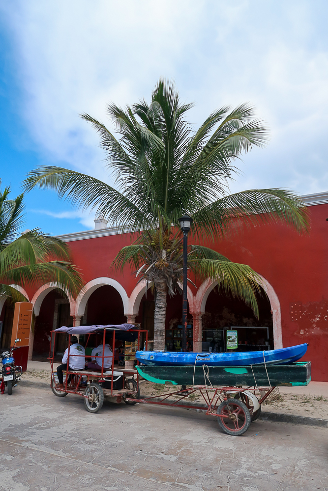 Tricycle carrying canoes on the back cargo along the streets of Sisal - a magical town in Yucatan