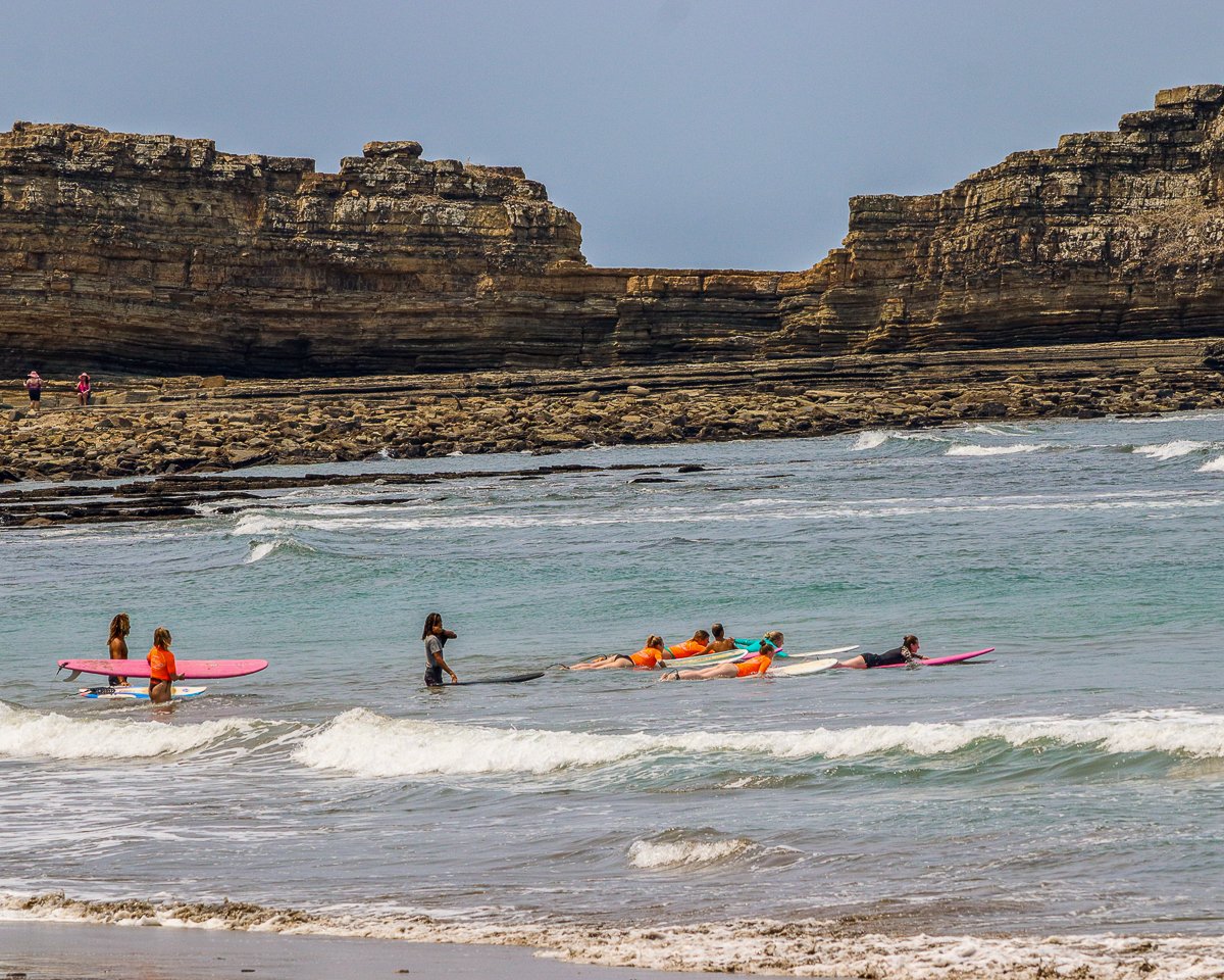 Group of people surfing the waves in Popoyo. Taking surf lessons is one of the things to do in Popoyo, Nicaragua.