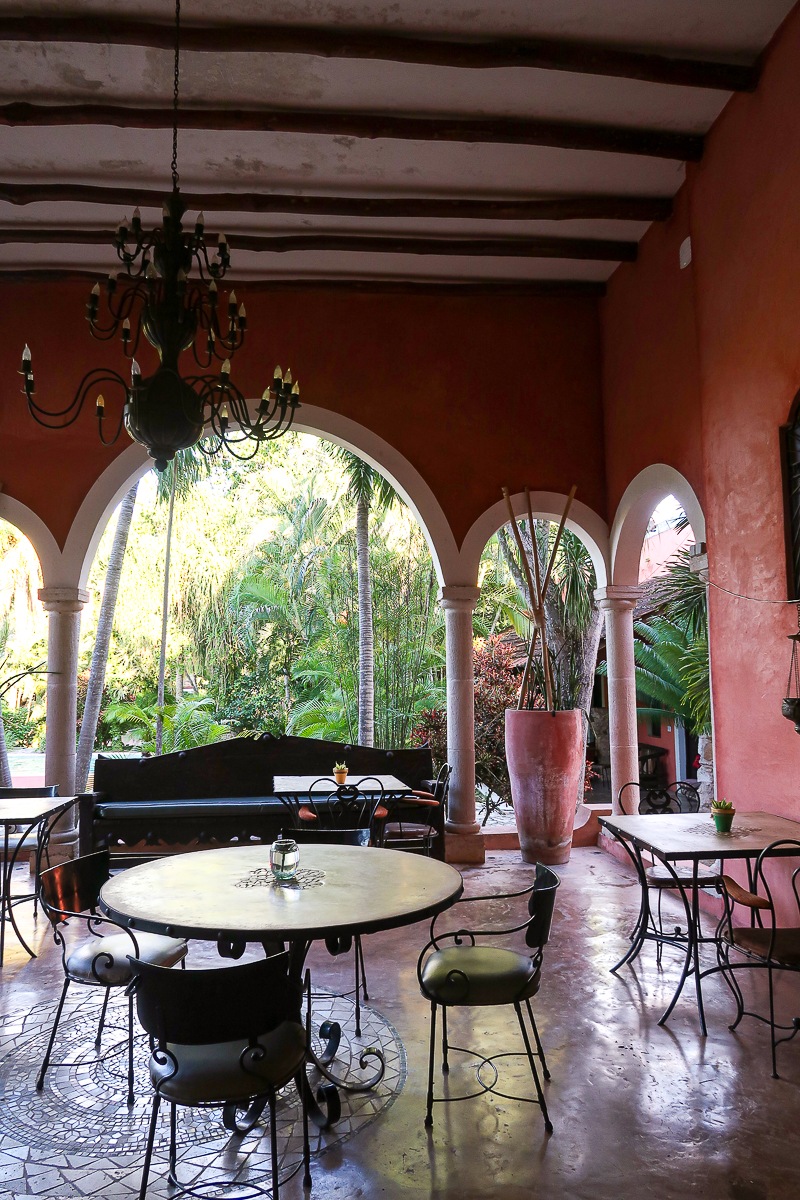 Tables and chairs in a covered patio at Hacienda Sacnicte